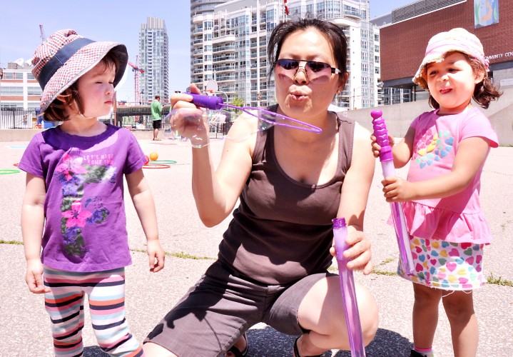 Mom Hattie, centre, blows bubbles with daughter Zia and neighbourhood friend Avalon at WNC's 25th anniversary.